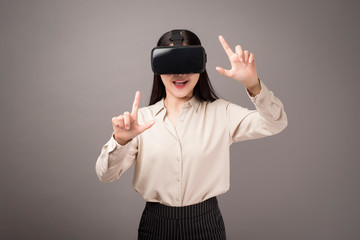 beautiful woman is using virtual reality on gray background