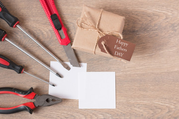 Top view of a greeting card with the handwritten inscription happy father's day, hammer, pliers,...