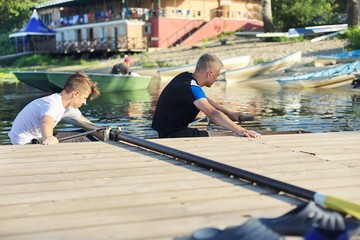 Team of two teenage boys kayaking on river
