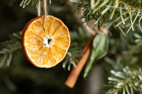 Zero waste christmas concept. Christmas tree decorated with ornaments made of natural materials - slice of dried orange and cinnamon stick, close-up