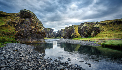 Impressively beautiful nature of Iceland. Canyon Fjadrargljufur during sunset is one famous natural landmark and travel destination place. Tipical Icelandic scenery with dramatic sky at sunrise