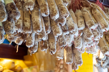 Many hanging air dried traditional handmade spicy sausages. Mediterranean delicatessen. Food background with copy space and shallow depth of field. Natural pattern