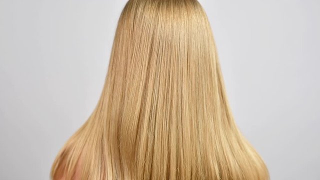 Haircare. Beautiful healthy straight hair. Woman moves blonde long hair.