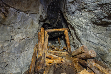Underground old mica mine tunnel with collapsed wooden timbering