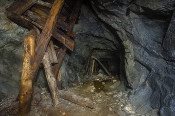 Underground old mica mine tunnel with collapsed wooden timbering