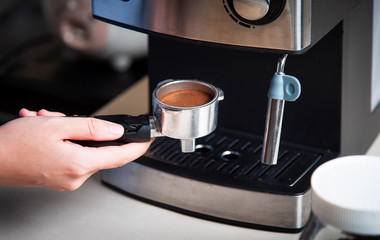 Person using espresso machine for making coffee at home