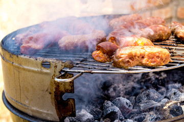 Sausages and frankfurters being cooked on the fire. Family barbecue.