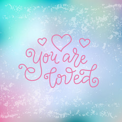 Modern mono line calligraphy lettering of You are loved in pink with hearts on blue pink