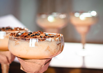italian dessert tiramisu in an elegant cocktail glass, the concept of sweet life, luxury, delicious food