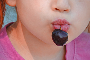   berry of cherries on a stalk in the teeth of puffy lips  
