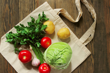 Eco bag and colorful vegetables on a wooden background. Zero waste, eco friendly, no plastic. Recycling concept eco-friendly. Copy space. Flat lay.