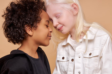 diverse black and albino kids in love, they have tender feeling for each other, people with unusual hair and skin color - obrazy, fototapety, plakaty