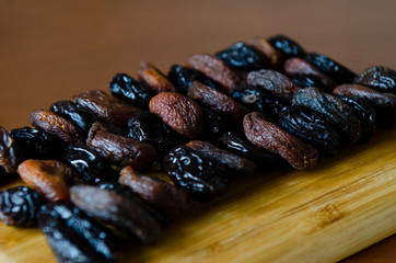 dried apricots and prunes on a wooden plate 
layers, dried fruits