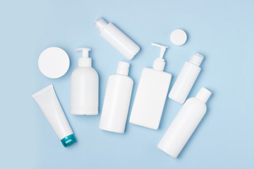 White plastic cans on a blue background. Cosmetics for skin care. Detergents, disinfectants and laundries