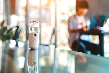 Alcohol nano mist sprayer for hand cleaning to prevent the spread of the corona virus (Covid-19) placed on the table to serve customers before buying in the coffee shop. Modern health technology.