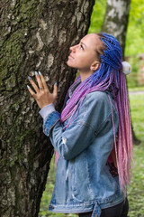beautiful girl with colored dreadlocks in a spring park