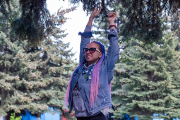 beautiful girl with colored dreadlocks in a spring park