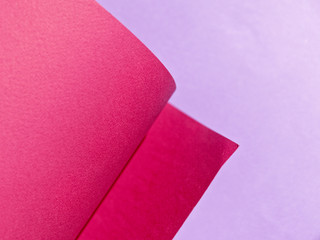 Abstract background made of red and purple sheets of thick paper twisted together. Shallow depth of field.
