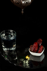 Muslim holiday of the Holy month of Ramadan Karim. Beautiful dates, a glass of clear water and a Fanus lantern 