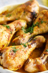 Fried chiken drumstick served in white bawl wiht spices, salad and turmeric