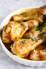 Fried chiken drumstick served in white bawl wiht spices, salad and turmeric