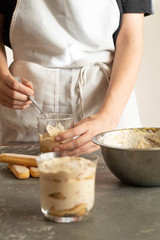 The recipe for tiramisu preparation, composition. Products on a grey table: egg yolk, nimbus, icing sugar.
