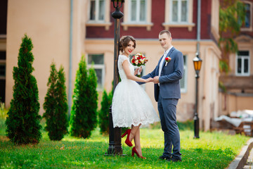 Bride and groom on their wedding day, walking outdoors in nature.