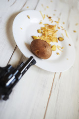 Despair, tired of cooking in the kitchen concept. A shot from a pistol at a potato.