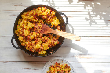 Baked potatoes with minced meat, onions and carrots baked in a pan.