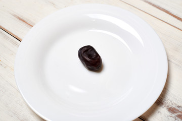Date on a plate on a light wooden background.