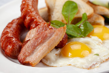 Sausages with  fried eggs,  bacon and toast