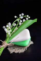 Cosmetic soap with a light scent of Lily of the valley on a black background.Designed for washing hands and body.