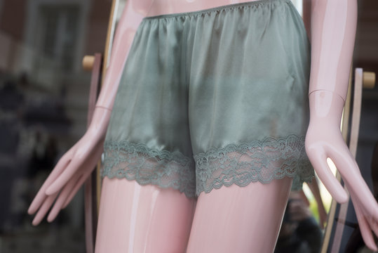 closeup of sgreen atin shorty on mannequin in fashion store showroom for women
