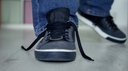 Man Preparing for a Walk with Laces Untied on His Sports Shoes