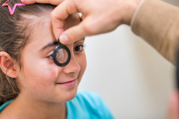 Young girl visitied by ophthalmologist in clinic. Diagnosis and correction of vision in children
