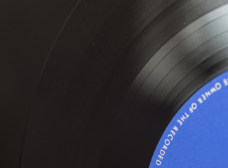 Black vinyl plate with visible music tracks on it, selective focus.