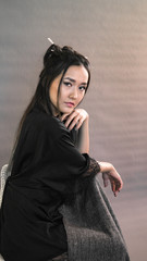 girl of oriental appearance on a gray background