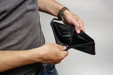 Man looks at an empty purse without money.There is no money crisis.
