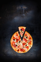 Pizza with a slice on a dark metallic background. Space for text, blank for a poster. Pizza menu....