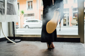 customer disinfecting her shoes with steam at the entrance to the store