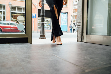 detail of a woman's legs entering a shop