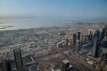view of Dubai from above from the observation deck of the Burj Khalifa skyscraper on Sheikh Zayed Highway, Persian Gulf in the daytime at sunset