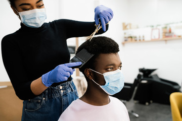 African-American hairdresser peeling an African-American man in a face mask