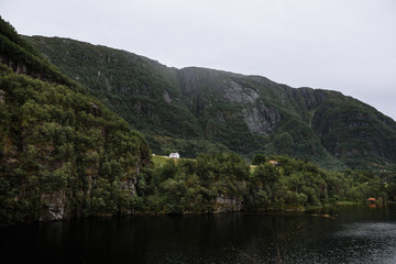 Fototapeta na wymiar Norwegian landscape. Village house standing on a rock