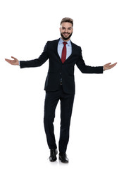 happy young guy in suit walking and opening arms