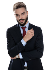 sexy young businessman holding arms in a fashion pose