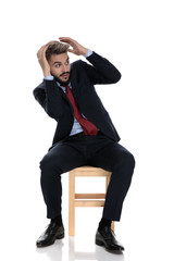 young businessman in suit holding hands up and defending