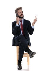 young businessman talking on the phone and showing middle finger