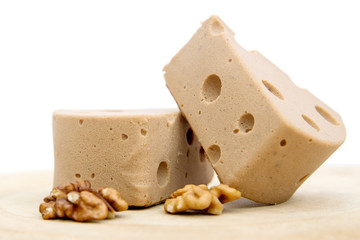 a piece of delicious beige milk nut cheese, for children and gourmets, white background, close-up