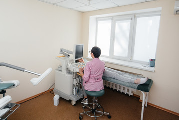 A pregnant girl gets an ultrasound of her abdomen at the clinic. Medical examination